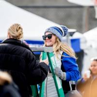 An alum is interviewed on a ladder during the tailgate